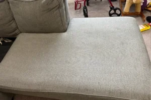 Same gray sofa seat with pet stains gone and even color restored after a deep upholstery clean by Couch Steamers