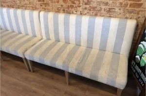 Blue and white striped bench seating with heavy gray soil lines before upholstery cleaning in Atlanta by Couch Steamers