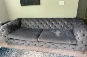Gray velvet tufted sofa with flat, dull cushions and body soil before sofa cleaning by Couch Steamers in Atlanta