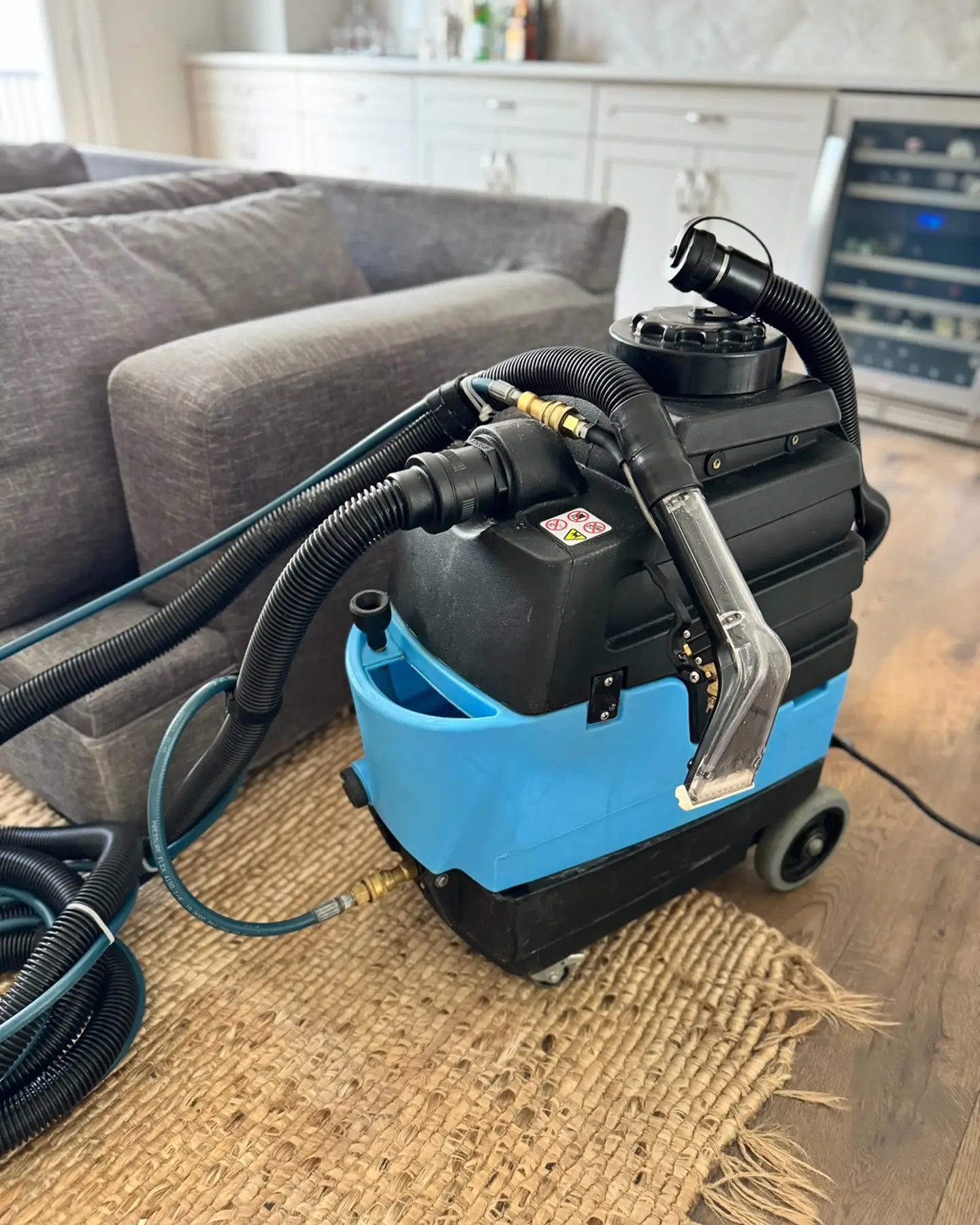 Professional couch cleaning extraction machine set up inside a home in Atlanta, GA, showing the in-home upholstery cleaning process and equipment used for deep fabric cleaning.