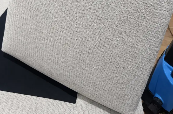Close-up of a fabric couch cushion after professional upholstery deep cleaning with cleaner and more even fabric appearance.