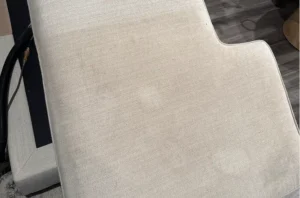 Light fabric couch cushion before upholstery cleaning with dull appearance and light surface soiling prior to general refresh service.