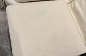 Clean cream ottoman after couch cleaning in Raleigh, NC, ink stain lifted with no ring left behind