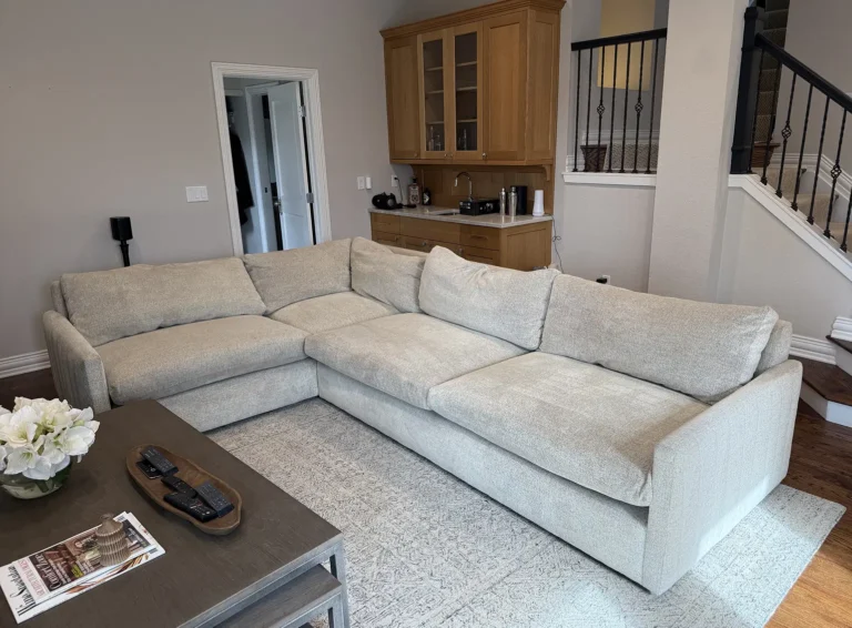 Clean light-colored sectional sofa in a living room after professional upholstery cleaning, showing refreshed fabric and organized seating cushions.