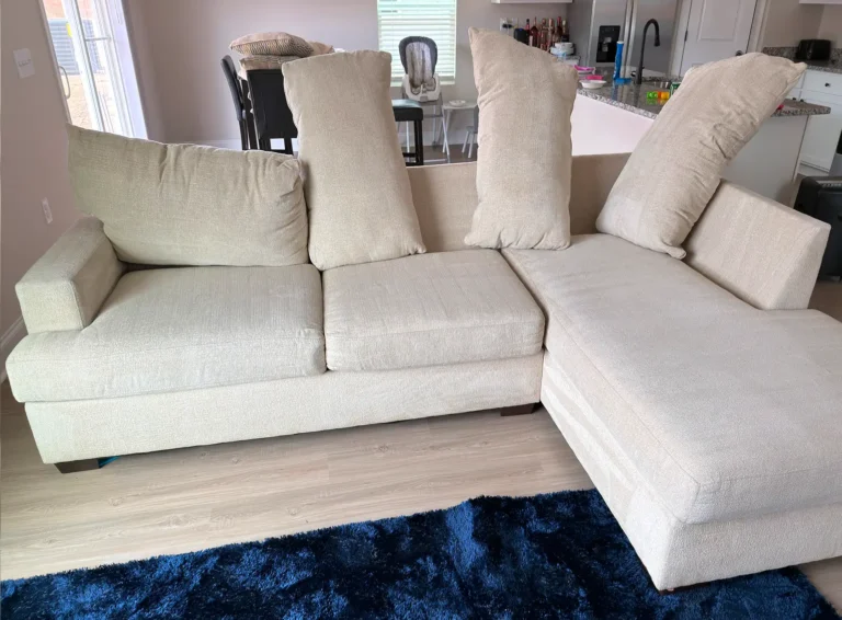 Sectional sofa with cushions removed and positioned for upholstery cleaning preparation, allowing detailed cleaning of seating surfaces and creases.