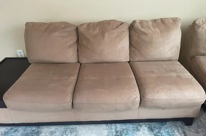 Fabric sofa after heavy dirt cleaning and upholstery deep cleaning with visibly cleaner seat cushions.