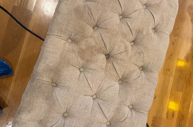 Tufted upholstered bench with visible old stains and aged spotting before professional upholstery cleaning in Atlanta, GA.