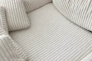 Cream corduroy couch after pet stain upholstery cleaning services, with clean ribs and no dark marks left behind.