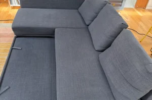 Gray sectional after steam couch cleaning, with brighter fabric, lifted pile and a fresh, evenly clean surface.