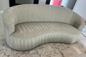 The same curved sofa after professional sofa cleaning in Denver, CO, with fresh fabric and no pet stains or odor left behind.