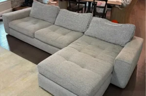 White sectional sofa with set in old stains before upholstery fabric cleaning in Denver, CO by our couch cleaning team.