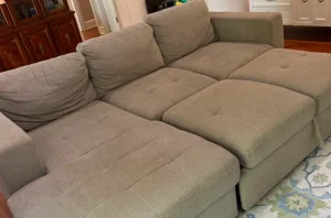 Dull, dusty beige sectional before upholstery fabric cleaning services in Dallas, TX by our trusted upholstery cleaning company.
