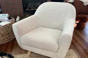 Same white boucle armchair after chair shampooing, with the fabric brightened and looking clean and cozy again.