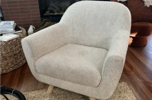 White boucle armchair before chair shampooing, looking dull and grayed from daily use and body oils.