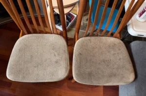 Two wooden dining chairs before chair shampooing, with pads darkened by heavy dirt and daily use.