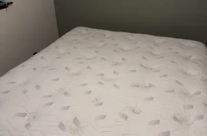 Same quilted mattress after steam mattress cleaning, with deep stains removed and the surface looking like new.