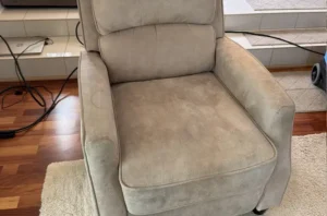 Beige microfiber recliner with dark pet stains on the seat before couch cleaning near me service call